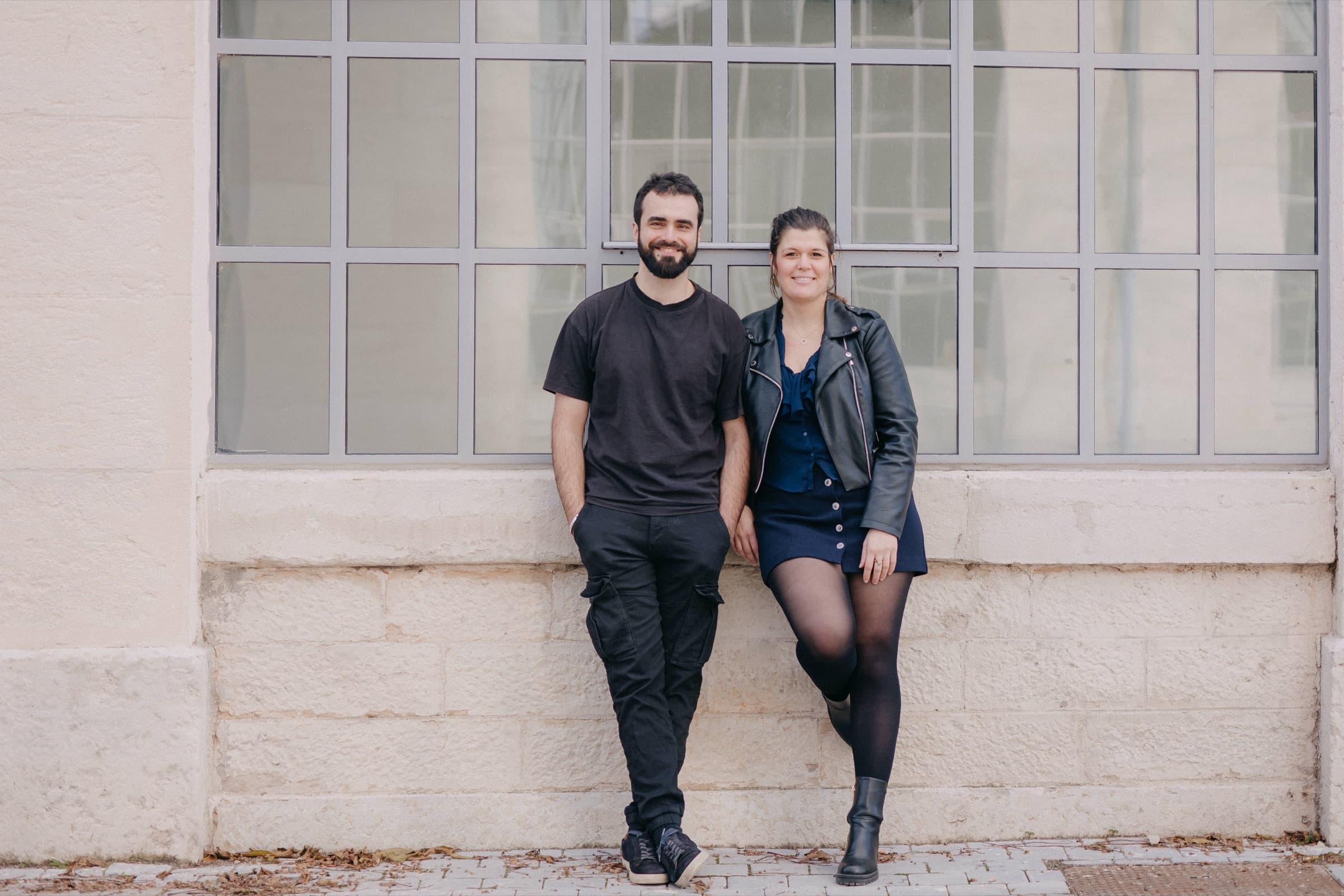 Jérémy et Marie-Charlotte, co-fondateurs de SafeKeeper, adossés à un mur devant une grande verrière